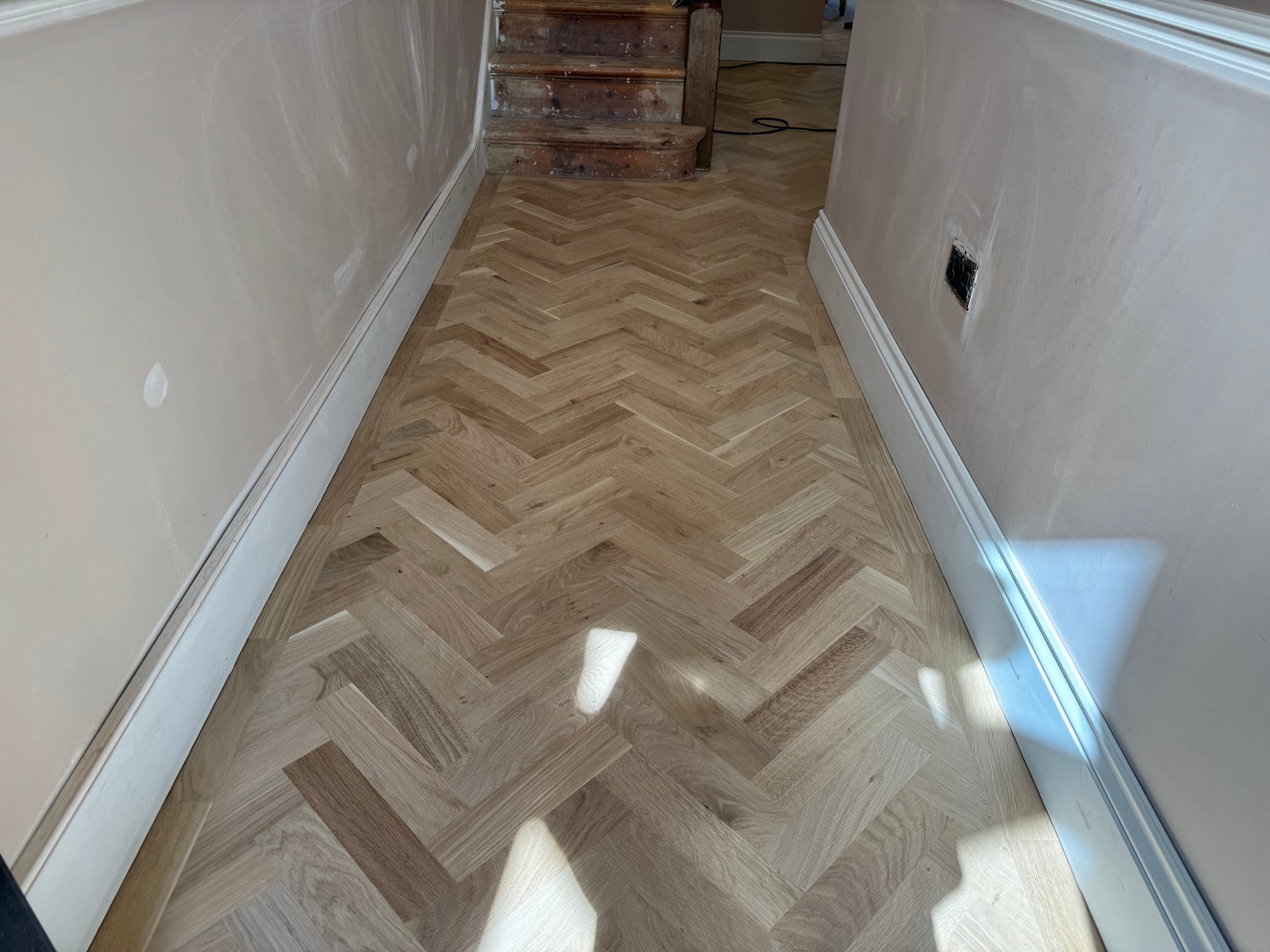 Refinished oak chevron parquet in a Barnes hallway